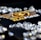 A collection of sparkling, clear gemstones surrounds a dark surface featuring the prominent logo and text 'Real Poker.' The logo design includes gold and white elements set against a black background.